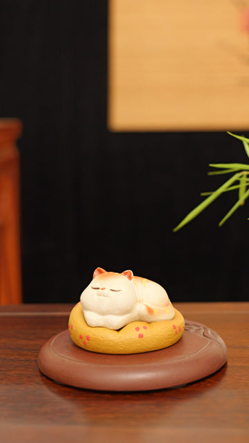 A kitten curled up in its cat bed handmade pottery figurine decor (tea pet) made by yixing purple clay
