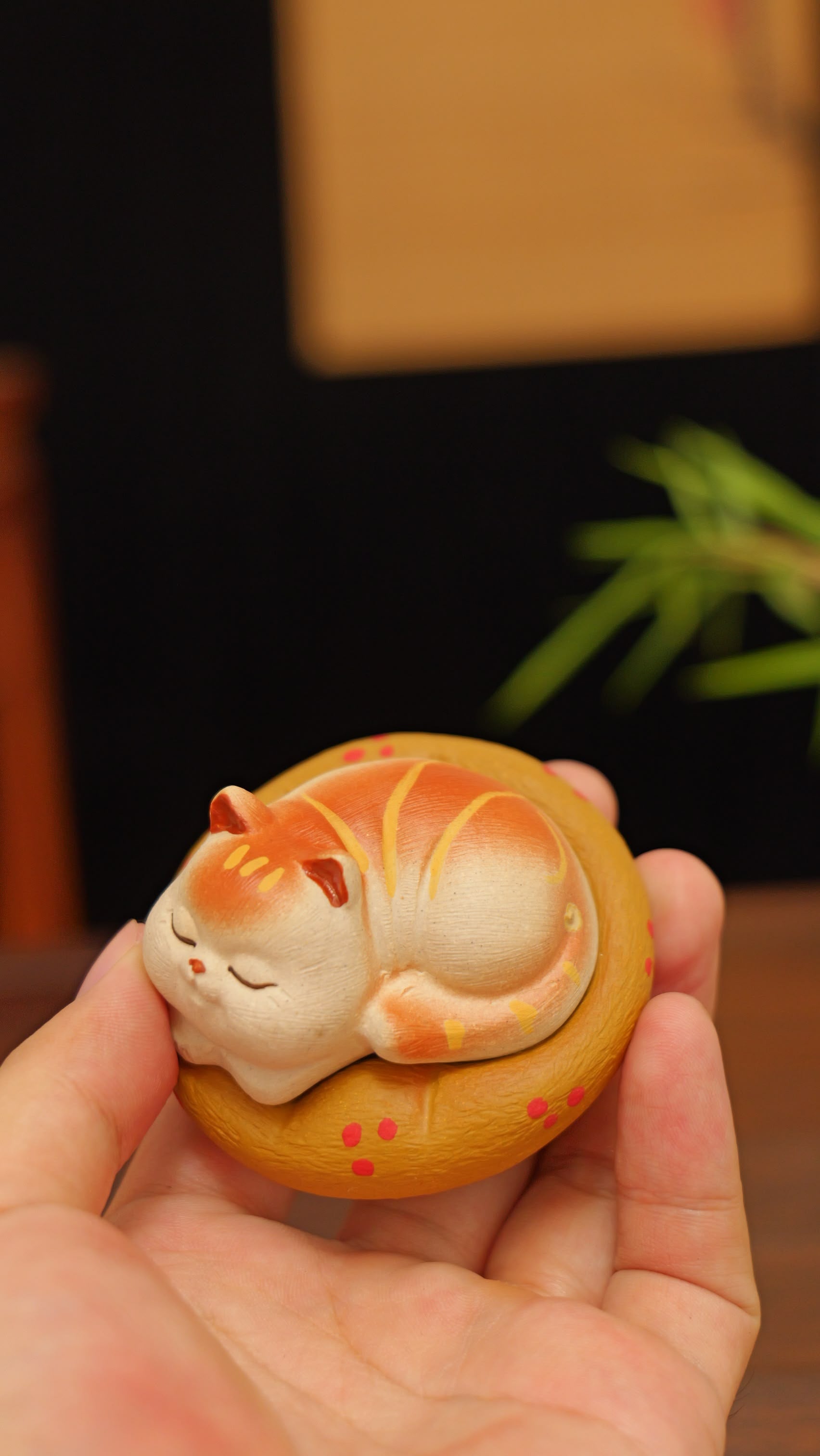 A kitten curled up in its cat bed handmade pottery figurine decor (tea pet) made by yixing purple clay