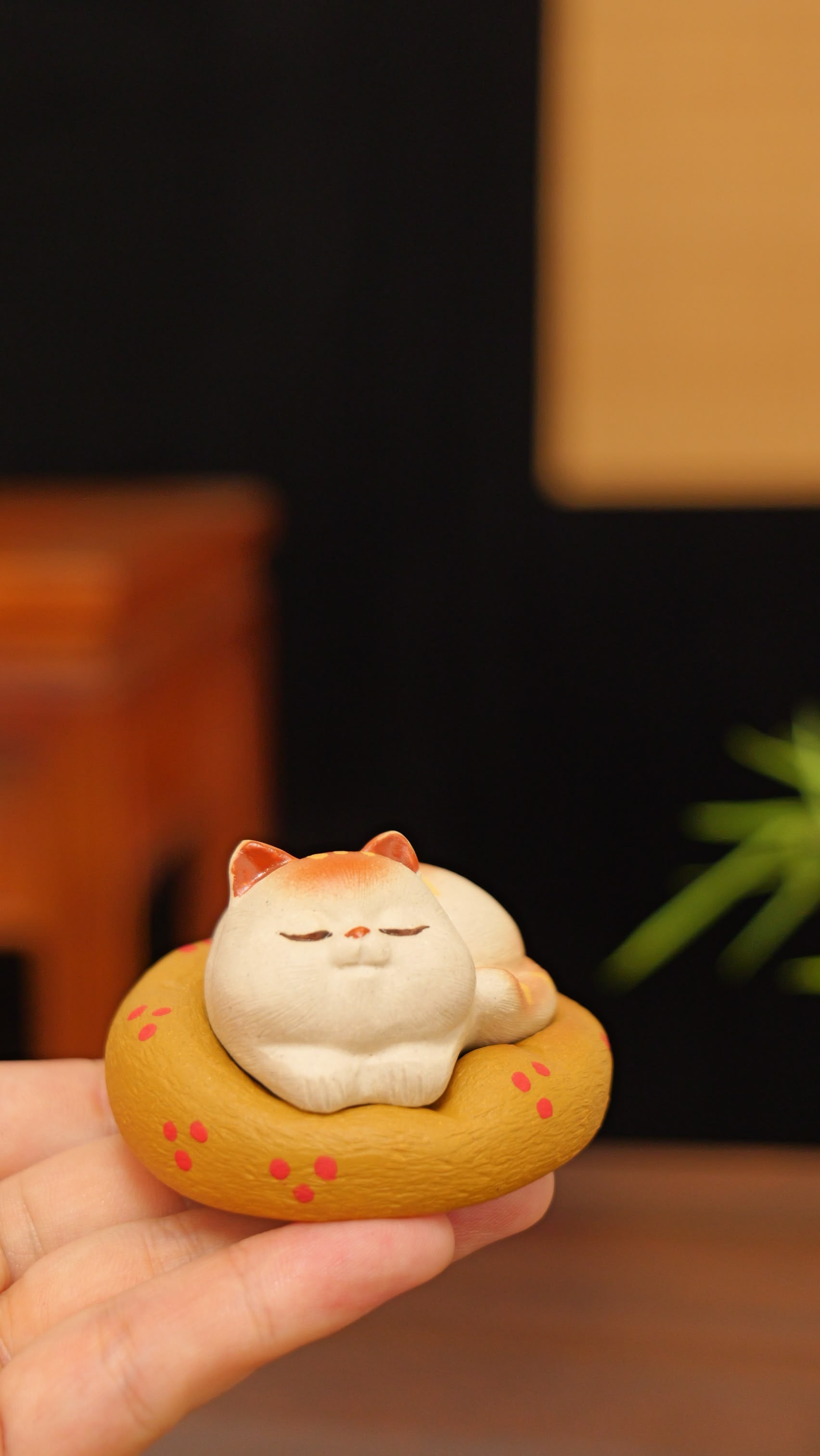A kitten curled up in its cat bed handmade pottery figurine decor (tea pet) made by yixing purple clay